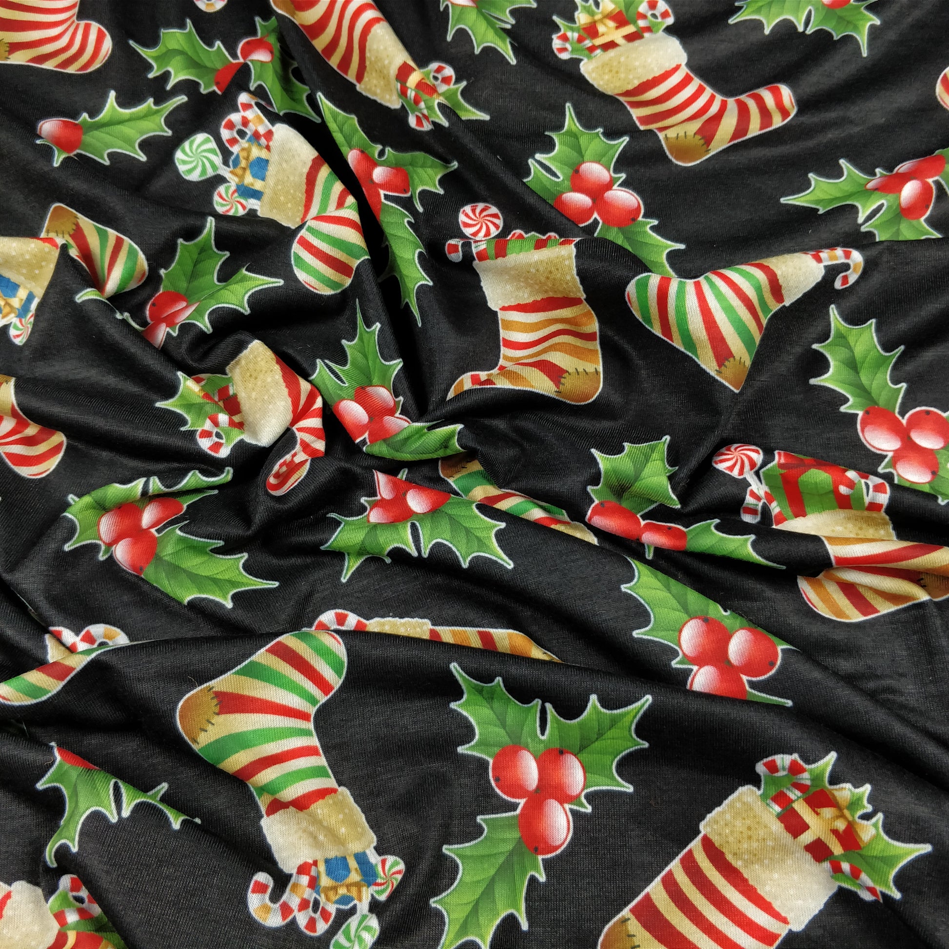FS078 Christmas Print, Stockings Holly | Fabric | Black, candy, Christmas, fabric, Holly, jersey, polyester, presents, Sale, spun polyester, Spun Polyester Elastane, Stocking, stockings, Sweets, xmas | Fabric Styles